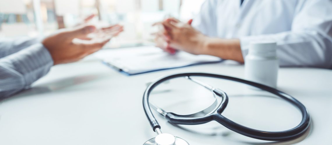 Doctors and patients consulting and diagnostic examining sit and talk. At the table near the window in the hospital medicine concept