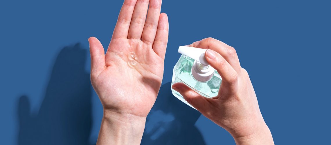 Applying sanitizer gel - healthcare and hygiene concept
