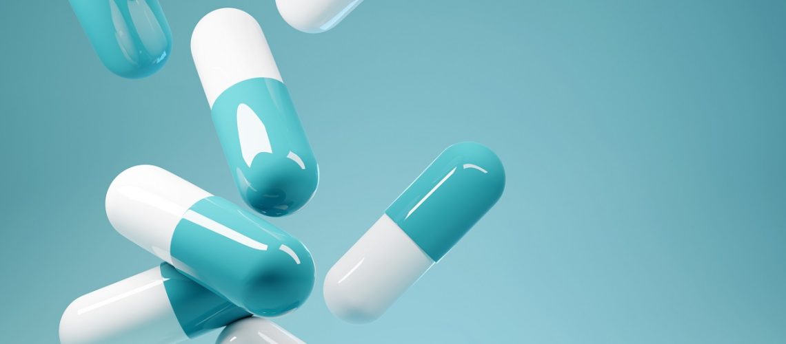 A group of antibiotic pill capsules fallling. Healthcare and medical 3D illustration background.