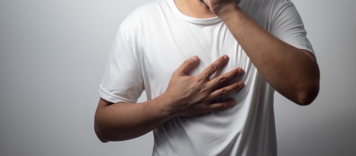 man wearing white shirt coughing on white background